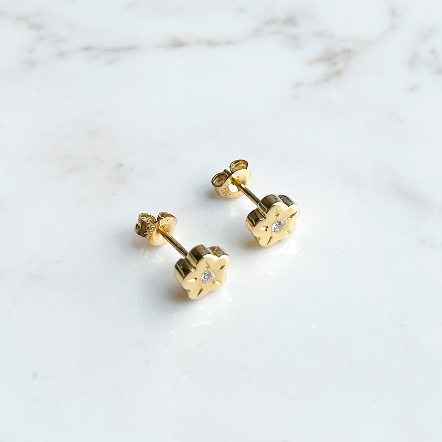 Aretes Flor con punto de diamante oro 18k