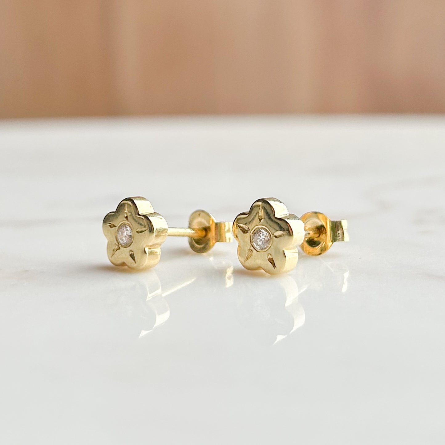 Aretes Flor con punto de diamante oro 18k