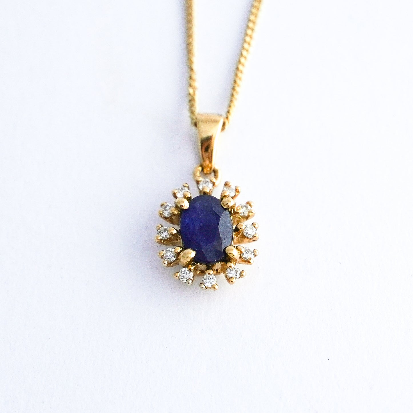 Dije corona azul con zafiro y diamantes naturales en Oro18k