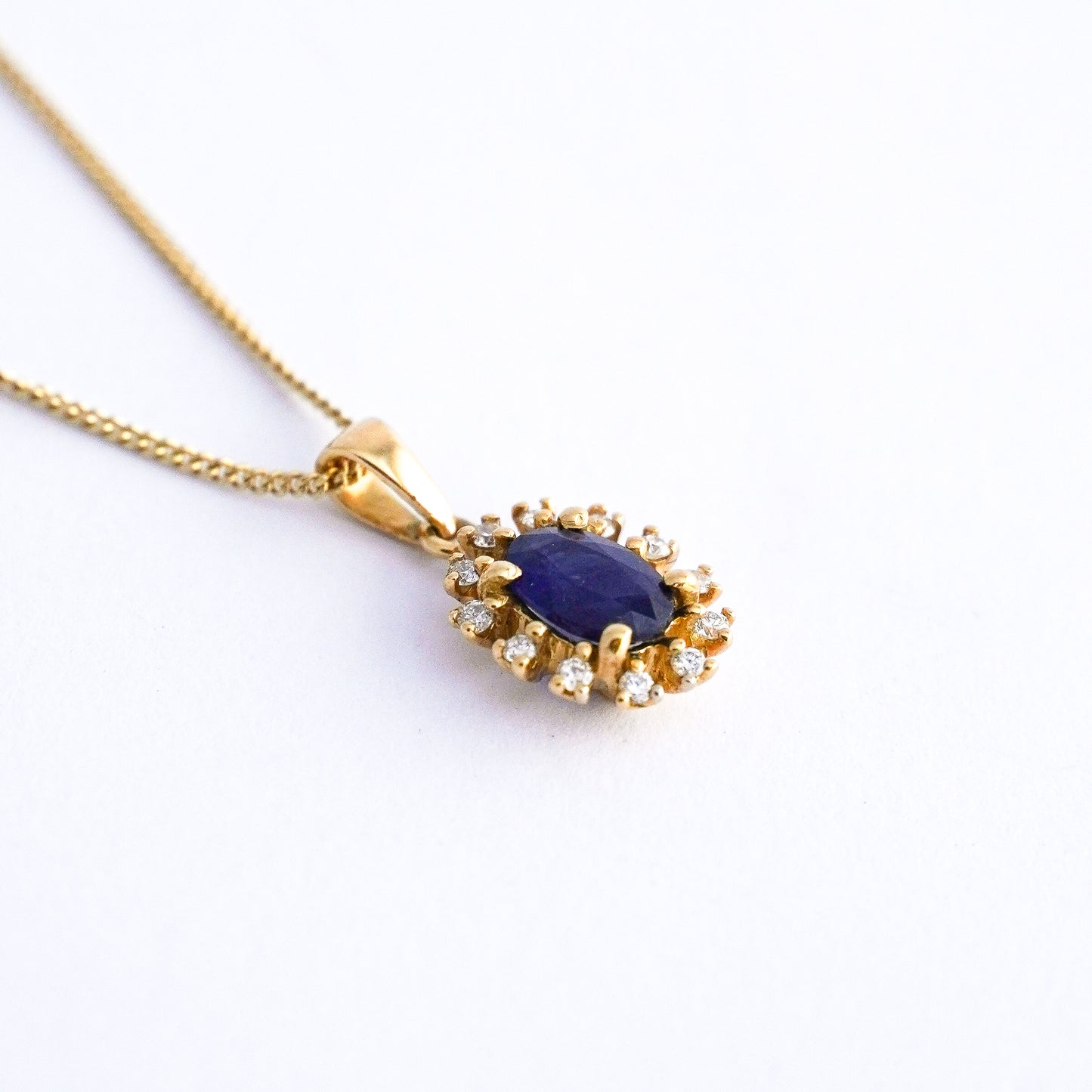 Dije corona azul con zafiro y diamantes naturales en Oro18k
