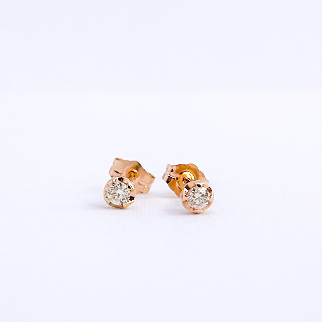 Aretes stud punto de luz con uñas y diamantes en oro 18k