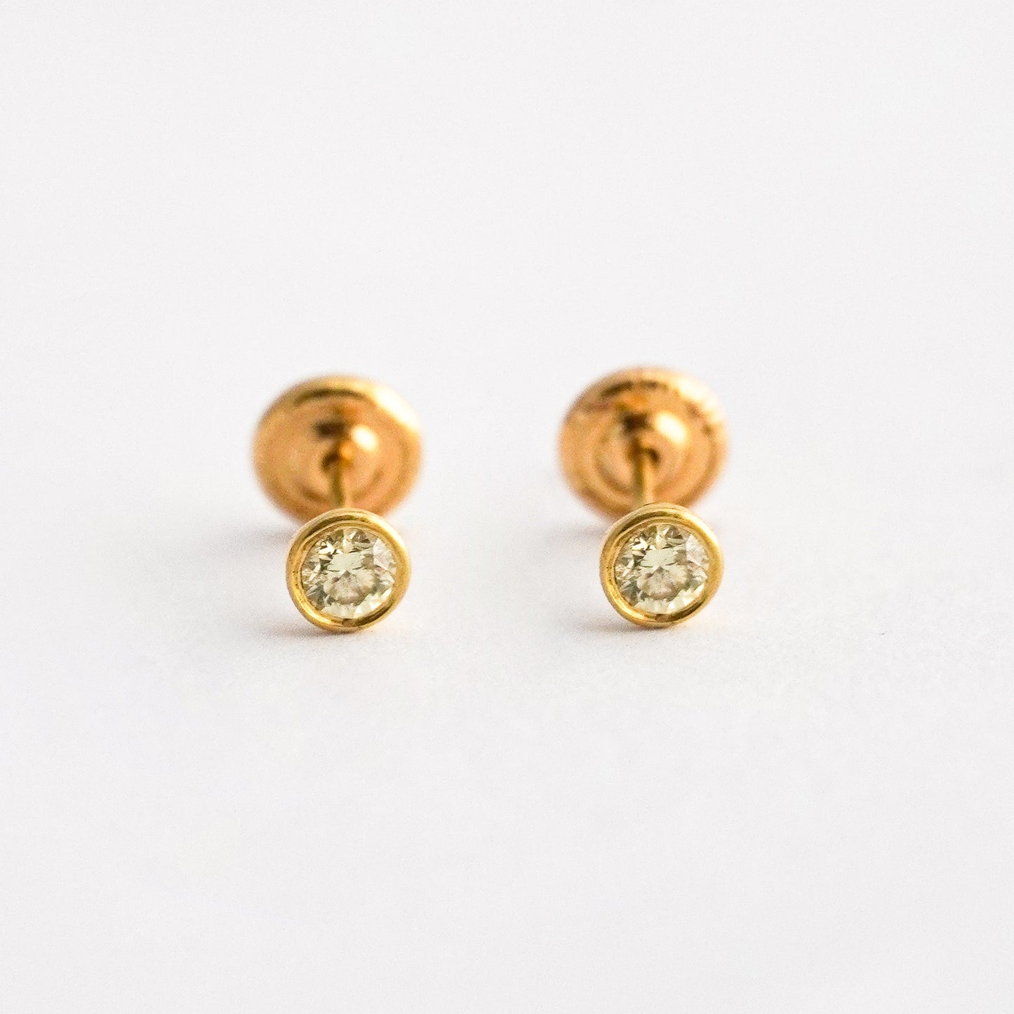 Aretes bebé punto de luz bicelado con diamante natural en oro 18k