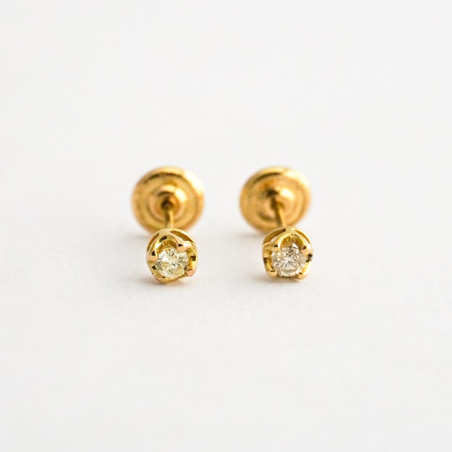 Aretes bebé punto de luz con uñas y diamantes en oro 18k