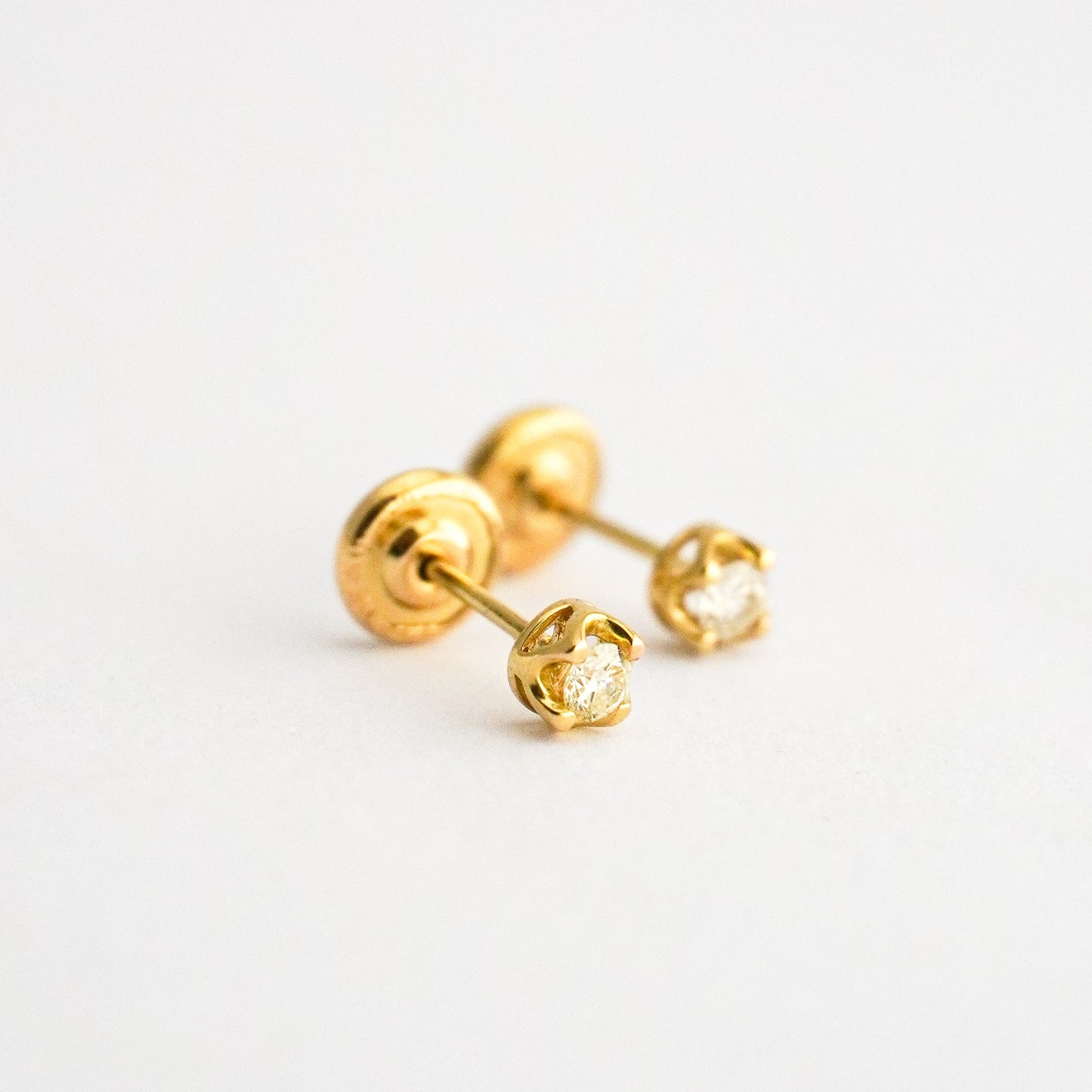 Aretes bebé punto de luz con uñas y diamantes en oro 18k