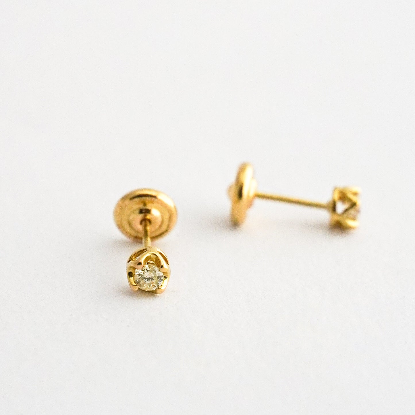 Aretes bebé punto de luz con uñas y diamantes en oro 18k