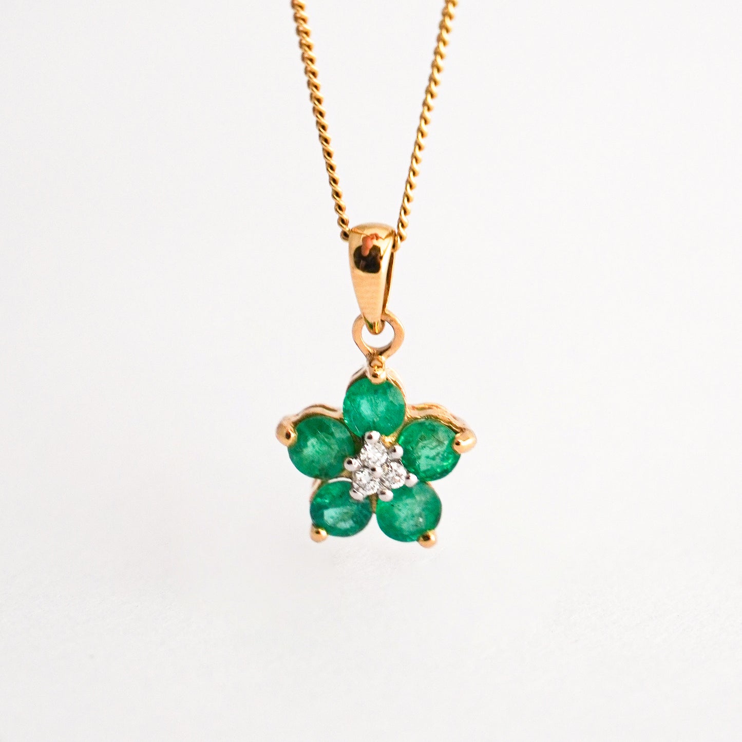 Dije Roseta trina con esmeraldas en oro 18k