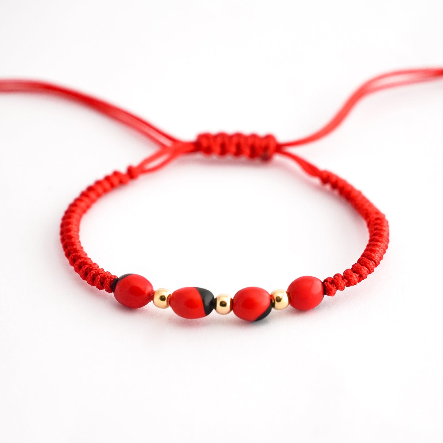 Pulsera tejida con huayruro en Oro18k