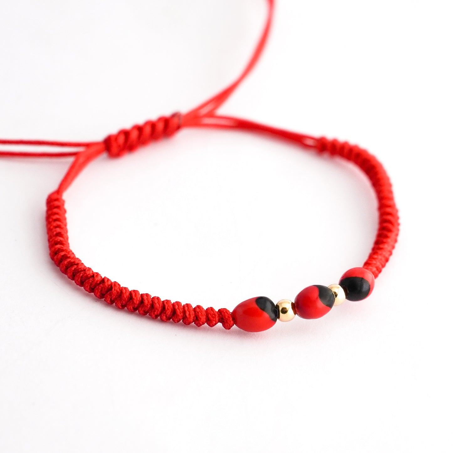 Pulsera tejida con huayruro en Oro18k