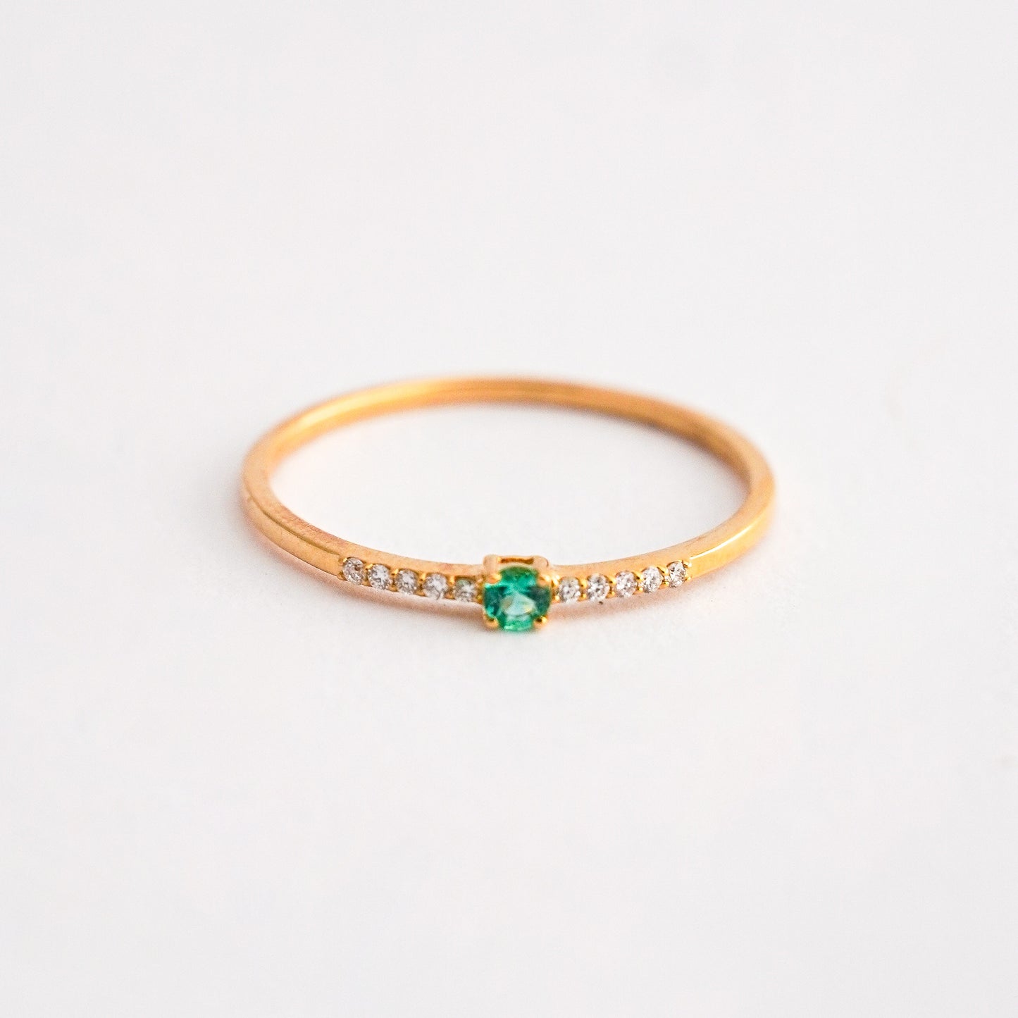 Anillo mini rivier con Esmeralda redondo en Oro 18K