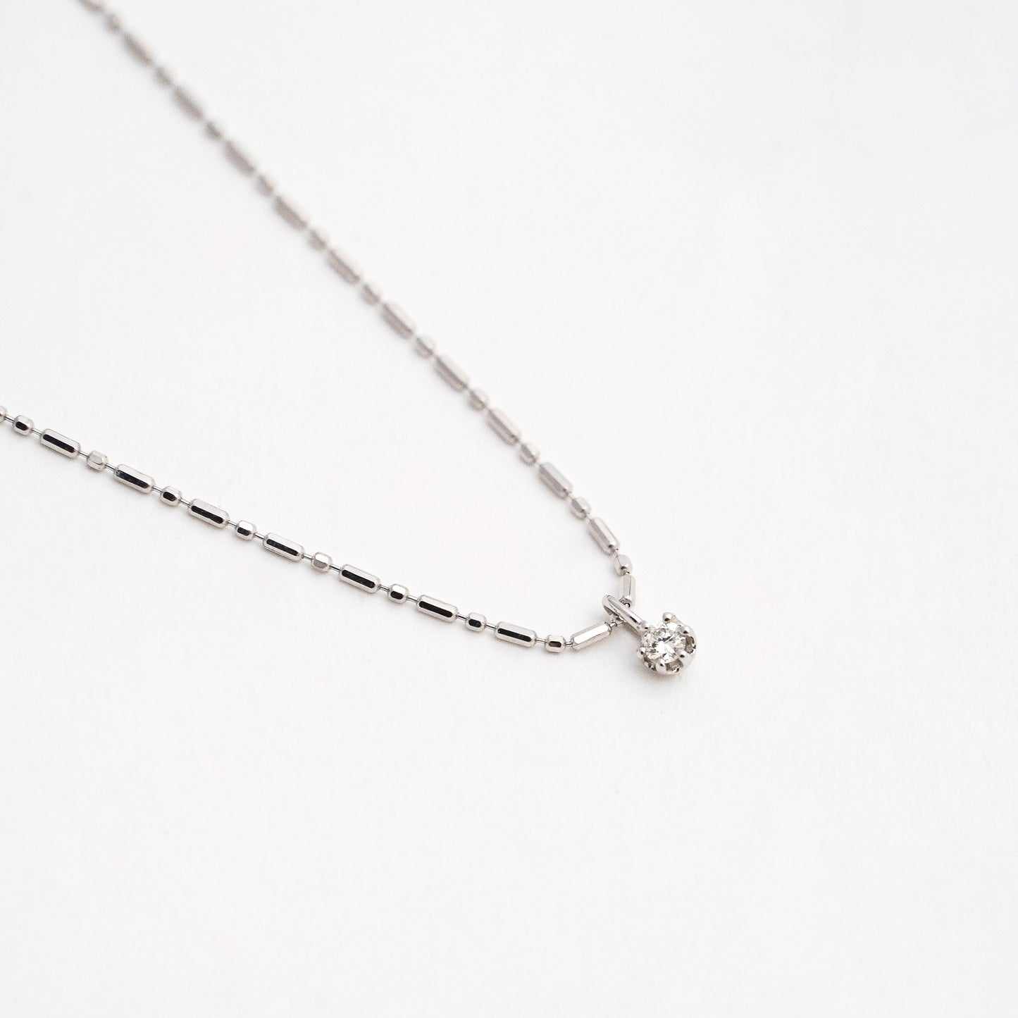 Cadena punto y coma con mini charm diamante natural 0.05 cts en Oro 18k blanco