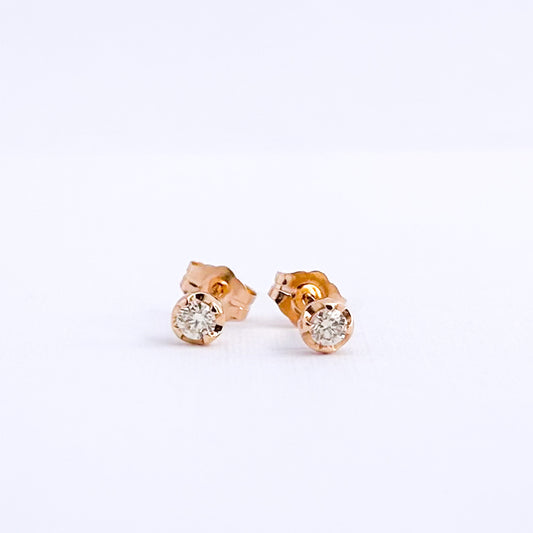 Aretes stud punto de luz con uñas y diamantes en oro 18k