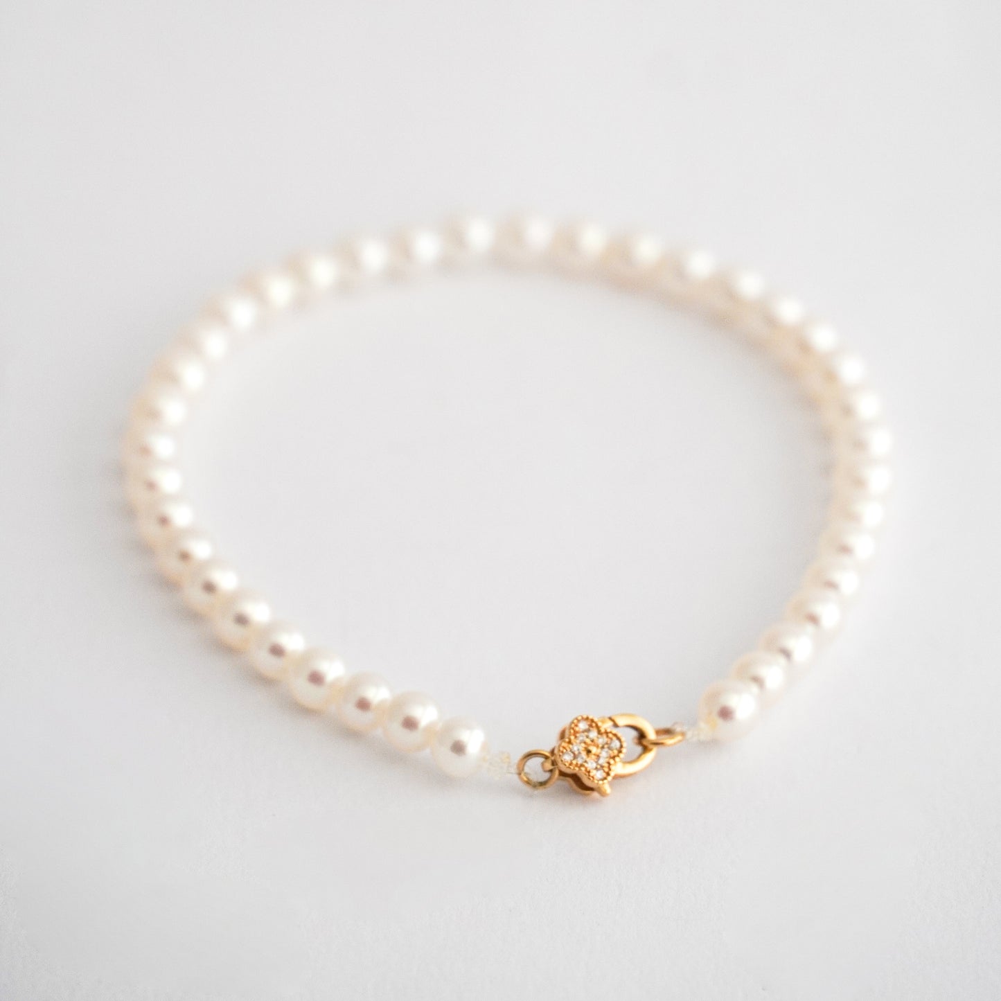 Pulsera de perlas cultivadas en oro 18k y broche trebol con diamantes naturales